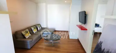 Modern living room with sleek furniture and wall-mounted TV, featuring a cozy sectional sofa and stylish decor.