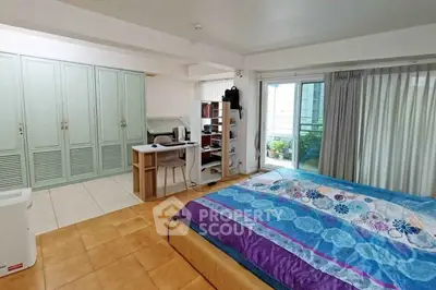 Spacious bedroom with balcony access and ample storage in modern apartment.