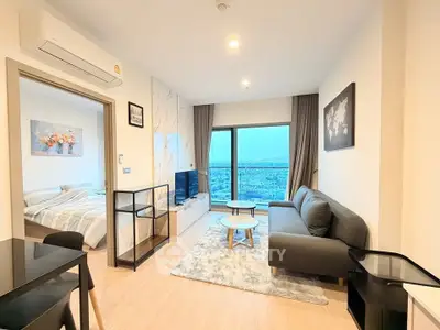 Modern living room with stunning city view, cozy sofa, and stylish decor in a high-rise apartment.
