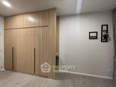 Modern bedroom with sleek wooden wardrobe and minimalist decor