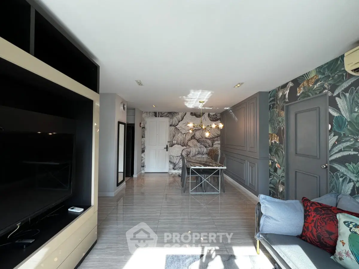 Stylish living room with modern decor and vibrant wallpaper, featuring a cozy seating area and sleek TV unit.