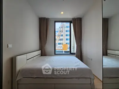 Modern bedroom with large window and city view, featuring a comfortable bed and sleek design.