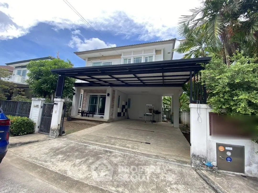 Spacious two-story house with carport and lush greenery