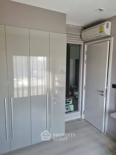 Modern bedroom with sleek wardrobe and air conditioning unit