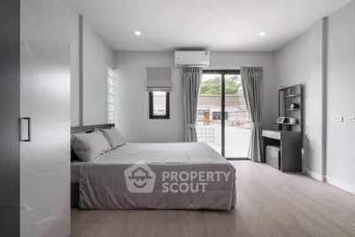 Modern minimalist bedroom with large window and neutral decor