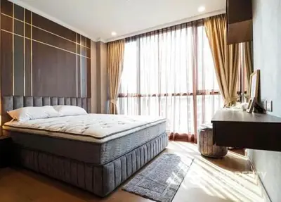 Luxurious bedroom with a large comfortable bed, elegant drapery, and warm natural lighting, perfect for relaxation and tranquility.