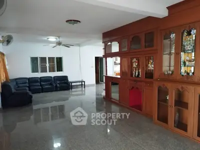Spacious living room with elegant wooden cabinetry and sleek leather seating.