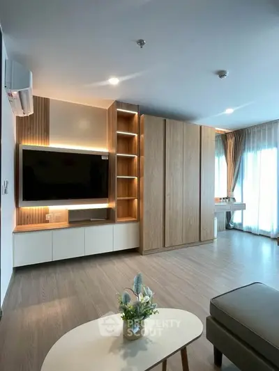 Modern living room with stylish wooden cabinetry and large windows for natural light.