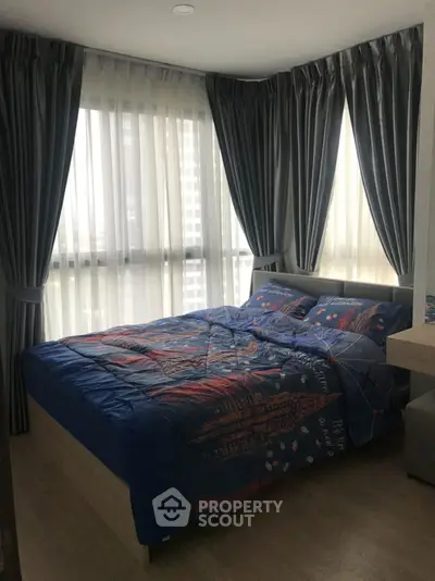 Cozy bedroom with large windows and elegant curtains in modern apartment.