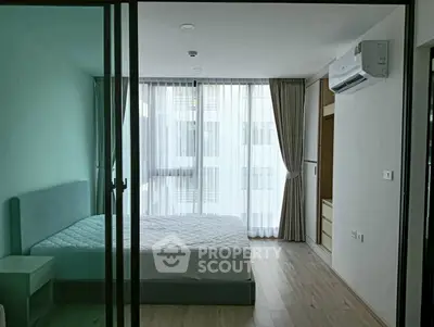 Modern bedroom with large windows and minimalist design in a high-rise apartment.