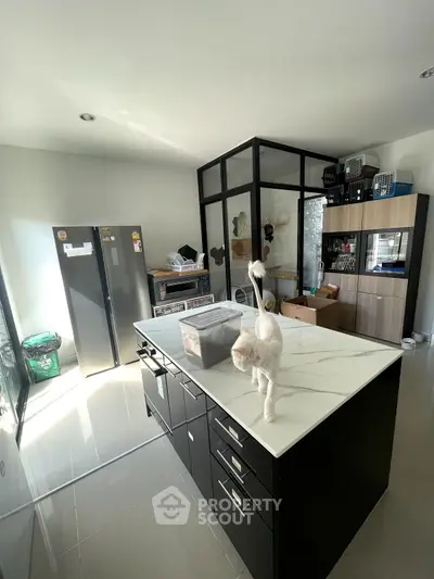 Modern kitchen with sleek island and stainless steel fridge in bright open space