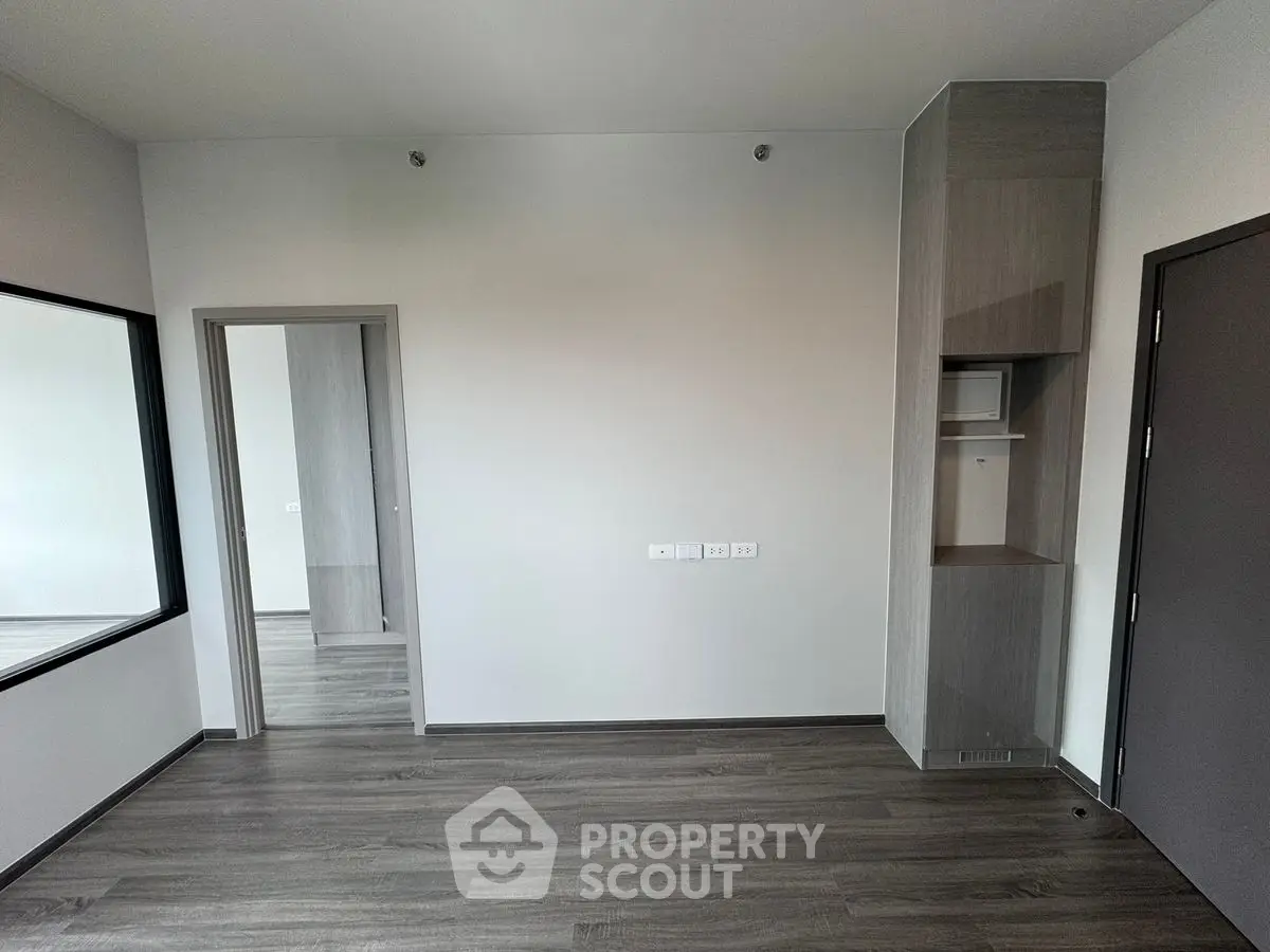 Modern minimalist room with sleek flooring and built-in storage, perfect for versatile living space.