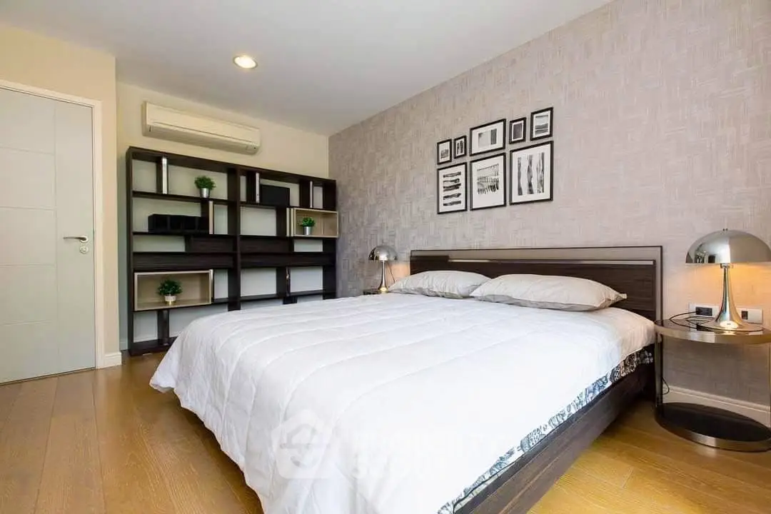 Spacious modern bedroom with stylish decor and ample natural light.