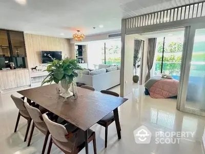 Spacious and bright living area with sleek dining set, modern sofa, and sliding doors leading to a lush outdoor view, perfect for entertaining.