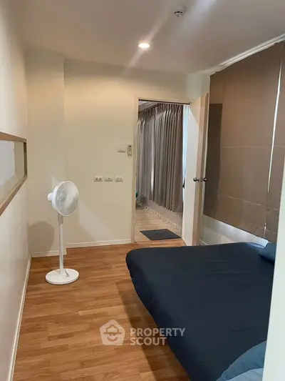 Cozy bedroom with wooden flooring and modern decor in a stylish apartment.