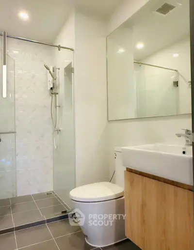 Modern bathroom with glass shower and sleek fixtures in a contemporary home.