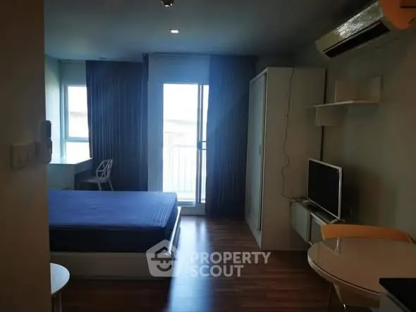 Modern studio apartment with balcony and sleek furnishings