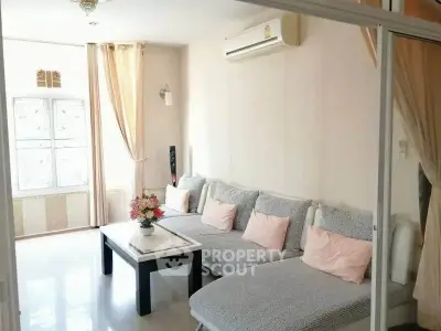 Bright and cozy living room with modern sofa and air conditioning, perfect for relaxation.