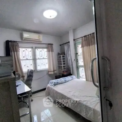 Cozy bedroom with natural light, air conditioning, and modern furnishings for a comfortable living experience.