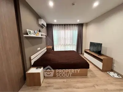 Modern bedroom with cozy decor, featuring a large bed, TV, and stylish shelving.