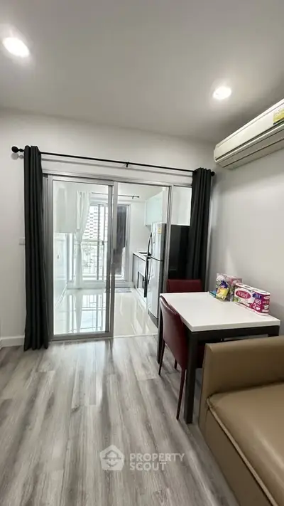 Modern apartment interior with sleek kitchen and dining area, featuring stylish flooring and ample natural light.