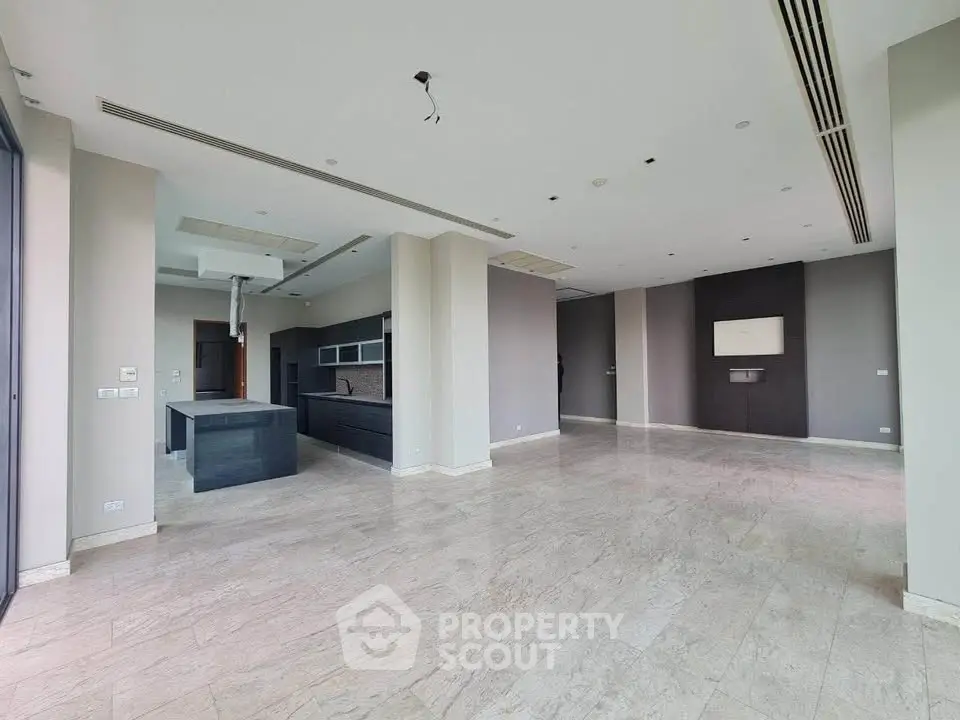 Spacious open-plan living area with modern kitchen and elegant flooring