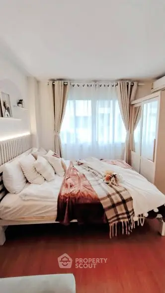 Cozy bedroom with elegant decor and natural light, featuring a comfortable bed and stylish curtains.