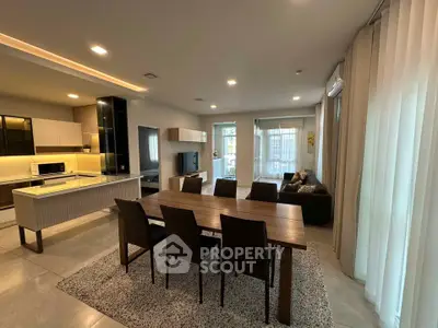Spacious modern living room with open kitchen and elegant dining area, perfect for entertaining.