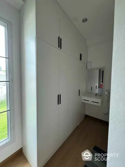 Spacious modern storage area with sleek white cabinets and natural light