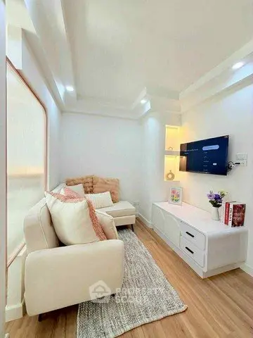 Chic and cozy living room with modern decor and wall-mounted TV, perfect for relaxation and entertainment.