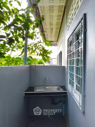 Charming outdoor sink area with lush greenery, perfect for a serene and functional space.