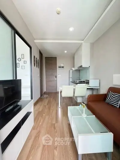 Modern living room with sleek furniture and open kitchen layout in a stylish apartment.
