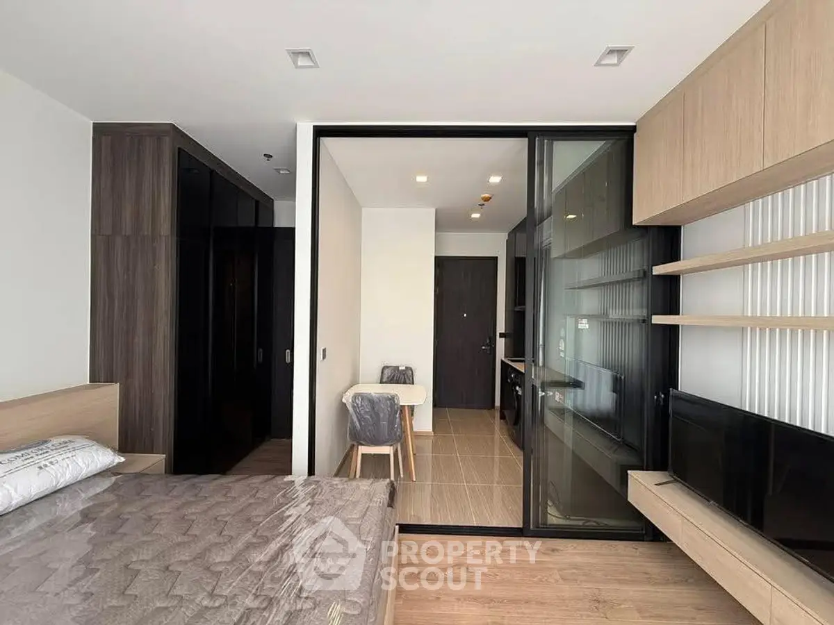 Modern studio apartment with sleek design and open layout, featuring a cozy living area and stylish furnishings.