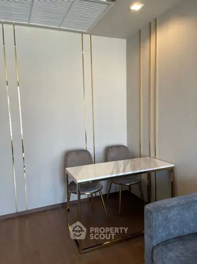 Modern study area with elegant marble table and plush chairs in a stylish apartment.