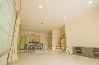 Spacious living room with dining area and staircase in modern home