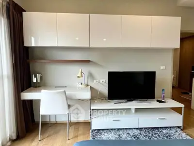 Modern living room with sleek white furniture and wall-mounted TV