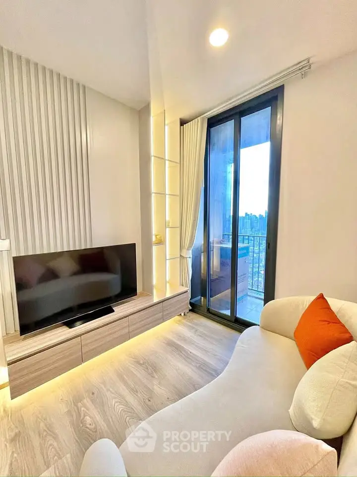 Modern living room with sleek TV unit and balcony view in stylish apartment.