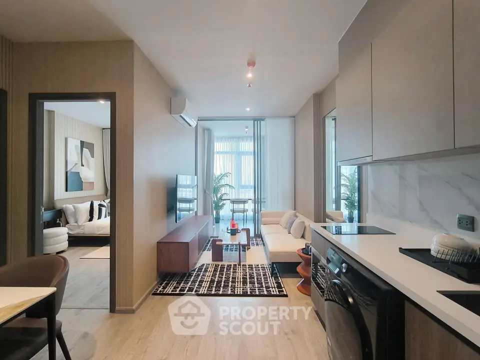 Modern open-plan living room and kitchen with stylish decor and natural light.