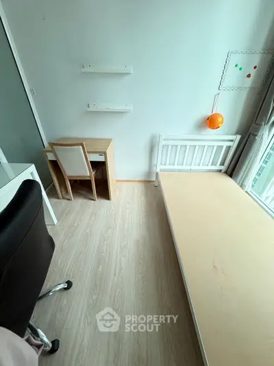 Cozy minimalist bedroom with desk and bed, ideal for small spaces.