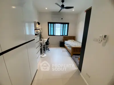 Modern bedroom with sleek design, featuring a cozy bed, study desk, and ample storage space.