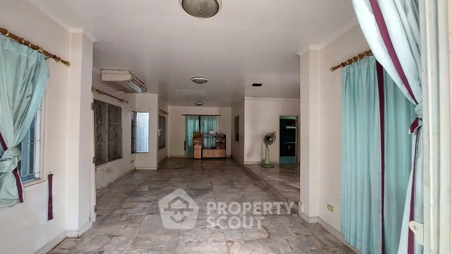 Spacious living room with tiled floors and large windows, perfect for natural light.