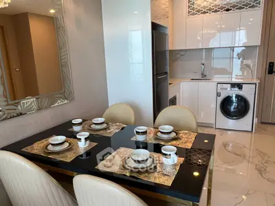 Modern dining area with elegant table setting and integrated kitchen appliances.