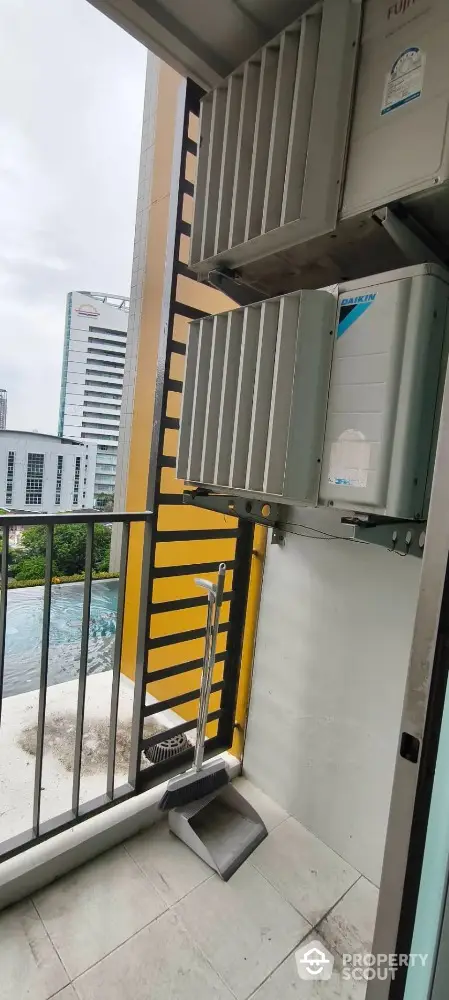 Modern balcony with air conditioning units overlooking cityscape and pool