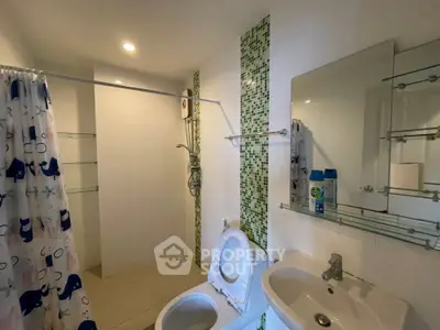 Modern bathroom with shower and stylish green tile accents