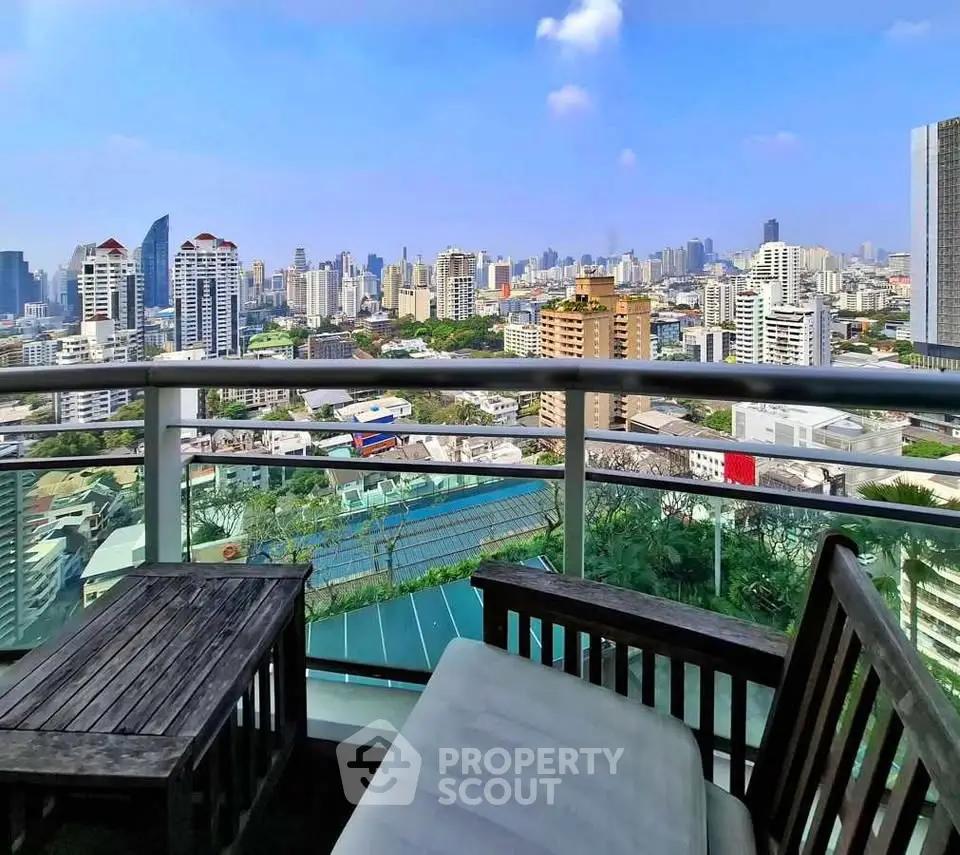 Stunning cityscape view from a modern balcony with stylish outdoor seating.