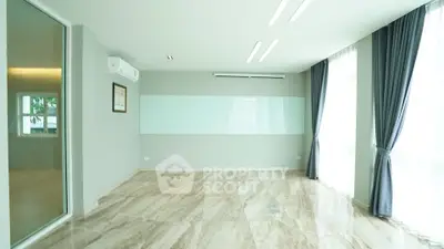 Spacious modern living room with marble flooring and large windows for natural light.