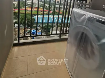 Balcony with washing machine and scenic view of sports field and cityscape.