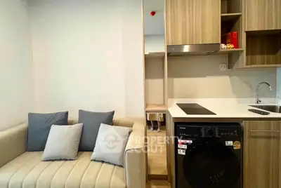 Modern compact living space with integrated kitchen and cozy seating area.