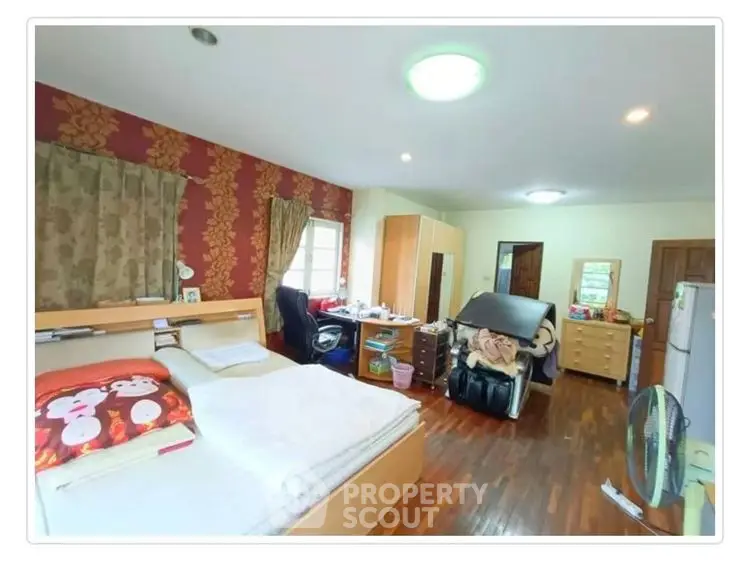 Spacious bedroom with wooden flooring and stylish decor