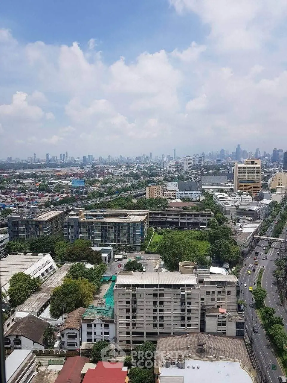 Stunning cityscape view from high-rise building showcasing urban skyline and lush greenery.